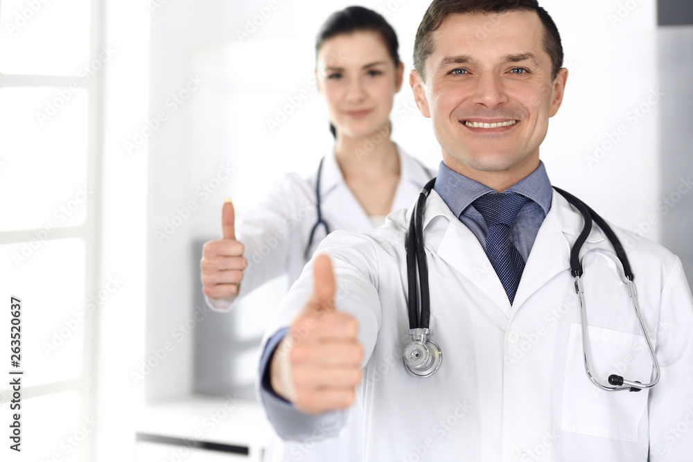 Group of doctors cheerful smiling at camera, thumbs up. Perfect medical service in clinic. Happy future in medicine and healthcare Group of doctors cheerful smiling at camera, thumbs up. Perfect medical service in clinic. Happy future in medicine and healthcare