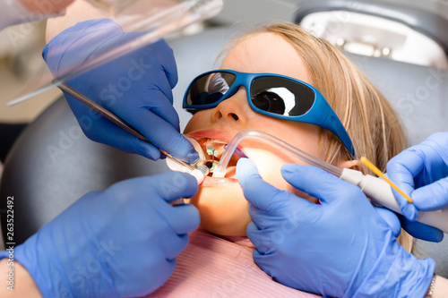 Little girl receiving dental procedure in pediatric dental clinic