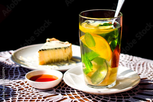 Fruit orange tea with mint, ginger and cinnamon. Orange slices in a glass cup close up