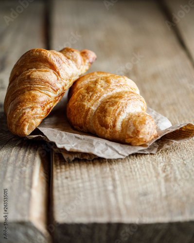 Freshly baked croissants on wooden rustic background. Tasty croissants with copy space