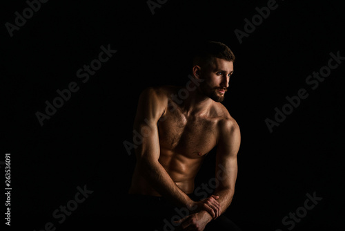 Muscular male bodybuilder on black background