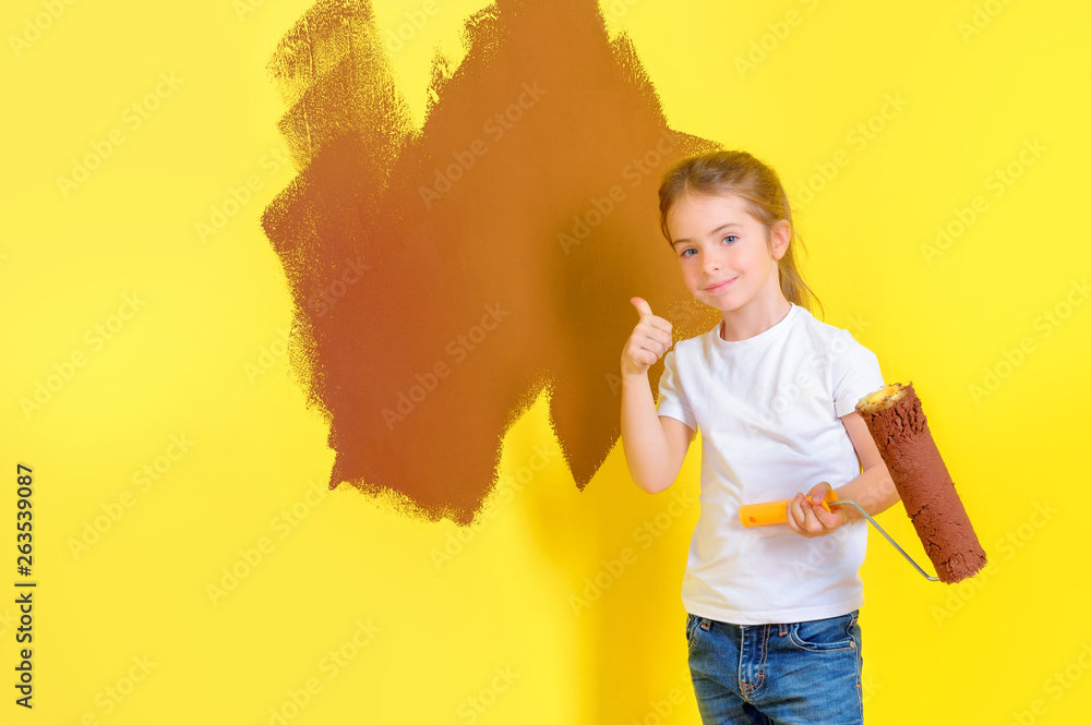 funny little girl with paint roller smiling and shows class near painted wall. Repair in the apartment. funny little girl with paint roller smiling and shows class near painted wall. Repair in the apartment.