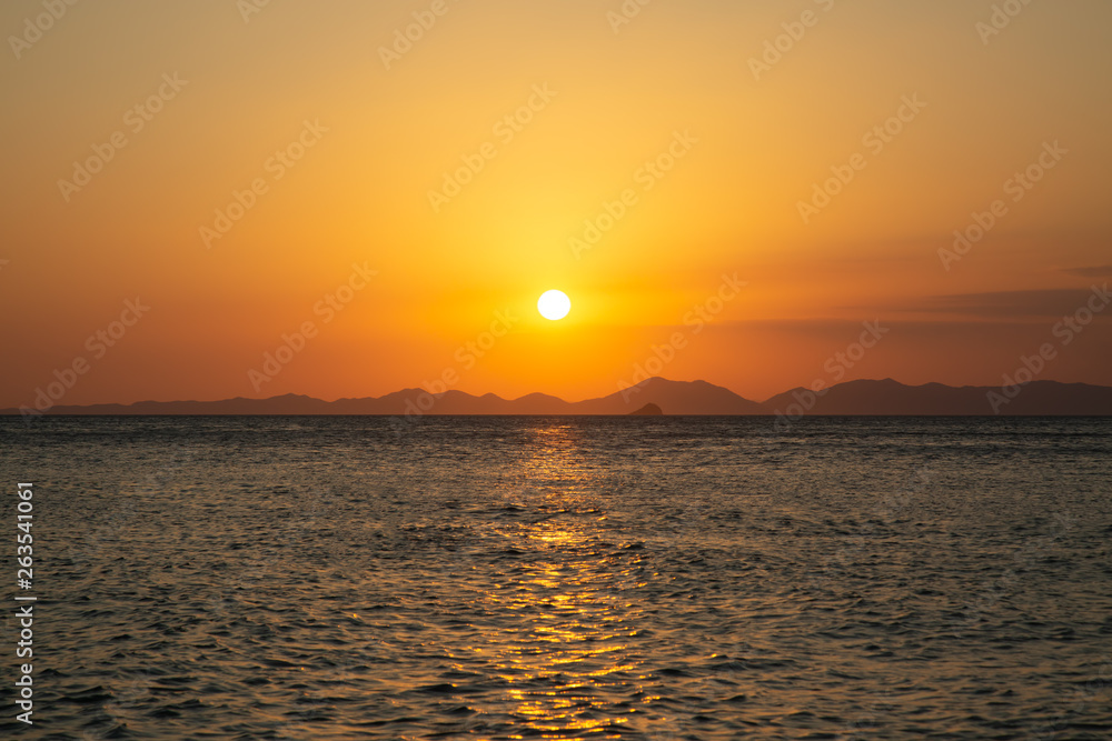 Beautiful golden sunset by the sea and the mountains