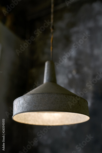 Hanging illuminated old lamp in shabby interior