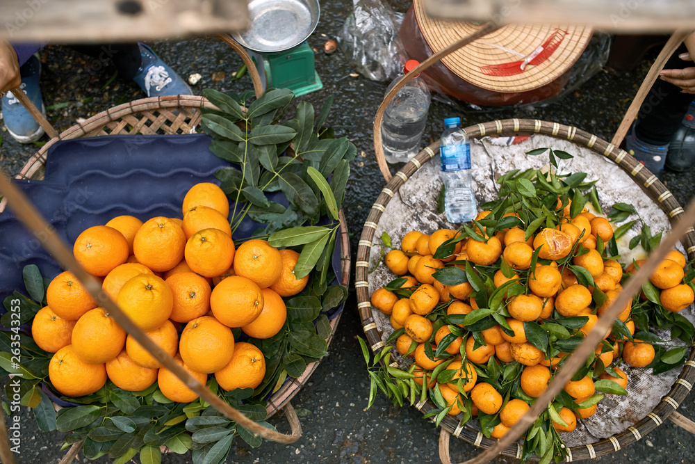 Tropical citruses lying in baskets on asian street market