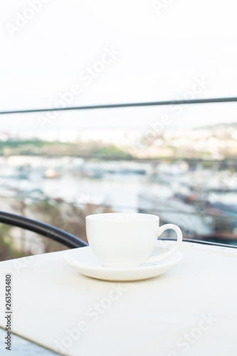 White ceramic cup with saucer on the table outdoor
