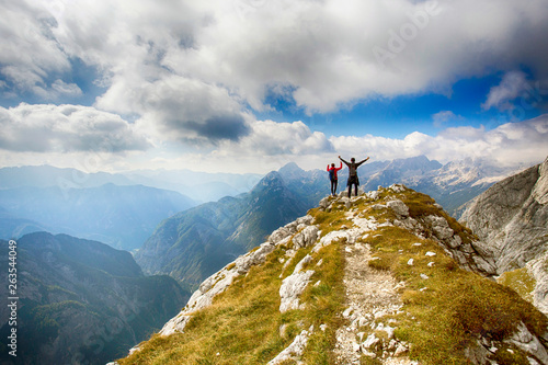 Hiker on hill under Prisojnik peak, Julian Alps, Slovenia. 