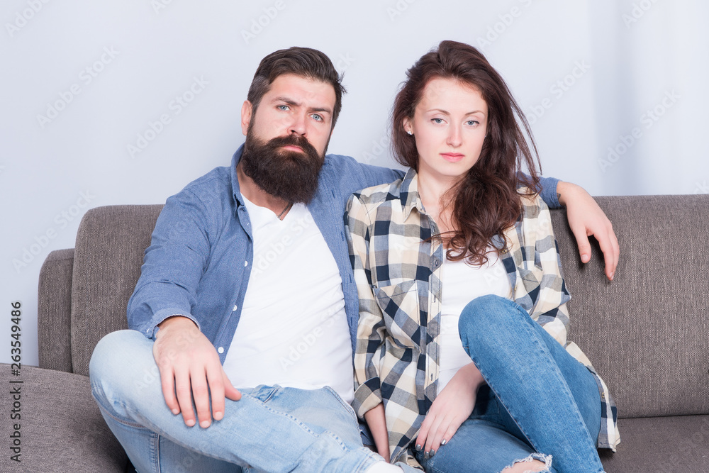 Regular couple relaxing on couch. Session at family psychotherapist. Couple in love hug looking at camera. Family relations. Family leisure. Happy and healthy relations. Bearded man and pretty girl Regular couple relaxing on couch. Session at family psychotherapist. Couple in love hug looking at camera. Family relations. Family leisure. Happy and healthy relations. Bearded man and pretty girl