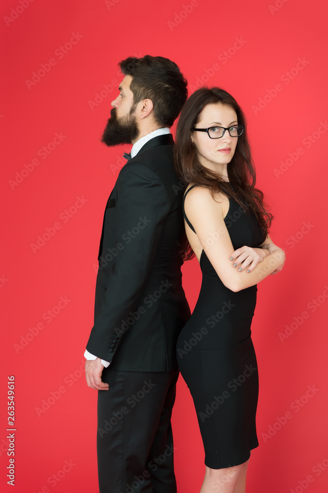 Man bearded hipster and woman in formal dress red background. Formal fashion and elegant clothes. Luxury fashion boutique. Fashion clothes shop. Official event. Couple man in tuxedo and elegant girl Man bearded hipster and woman in formal dress red background. Formal fashion and elegant clothes. Luxury fashion boutique. Fashion clothes shop. Official event. Couple man in tuxedo and elegant girl