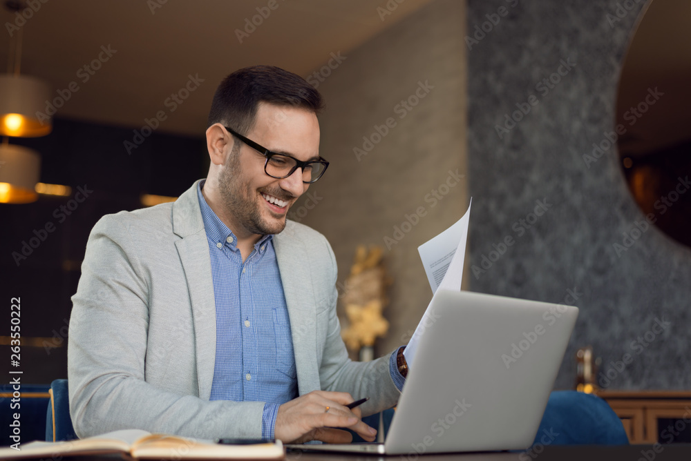 Happy businessman working on reports in the office Happy businessman working on reports in the office