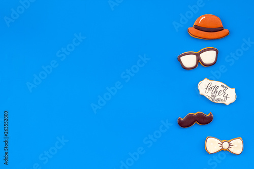 bow tie, moustache, glasses and hat for Happy Father Day party on blue background top view copy space