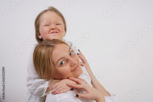 real family of caucasian mother and daughter in white shirts in the studio background