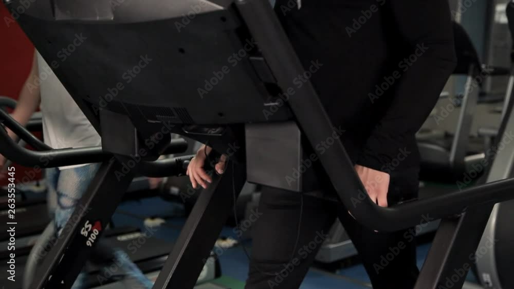 A young girl and a guy doing exercises in the gym on a treadmill. Sport, movement, health A young girl and a guy doing exercises in the gym on a treadmill. Sport, movement, health