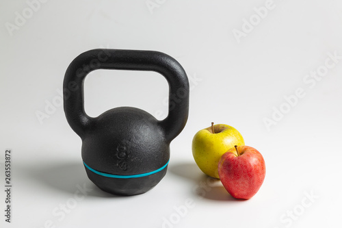 close up of a kettlebell and Red and green apple fruits
