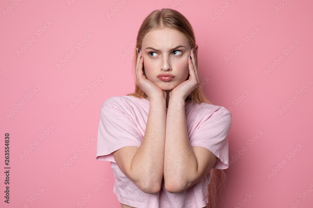 Close up portrait of young beautiful stressed angry girl holding hands on face Close up portrait of young beautiful stressed angry girl holding hands on face