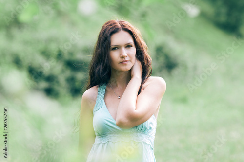 pensive young woman standing in summer Park.