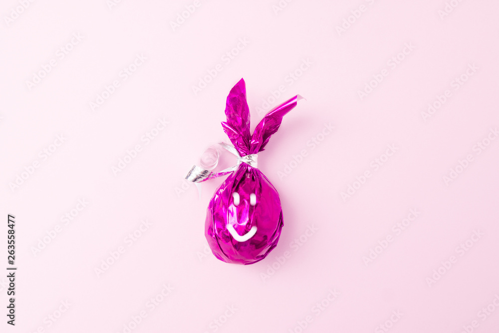 happy face Easter purple Eggs bunny ears on pink background. Flat lay, minimal style, trendy purple colors.