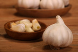 Garlic Cloves and Bulb in vintage wooden plate on wooden table.