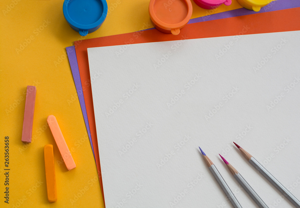 Colored paper and paints on the table. Colored paper and paints on the table.