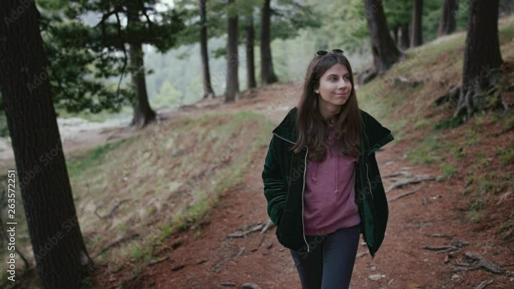 Teenage girl walking in the forest among pine trees Teenage girl walking in the forest among pine trees