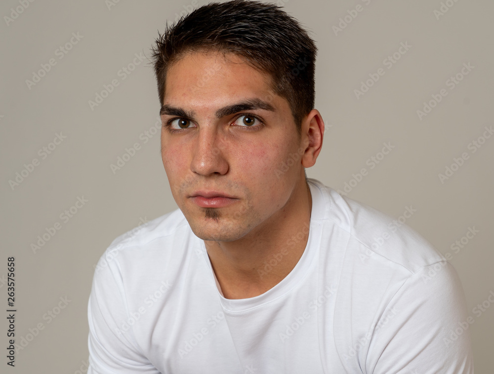 Natural portrait of young attractive man in his 20s looking and posing with neutral face expression Natural portrait of young attractive man in his 20s looking and posing with neutral face expression