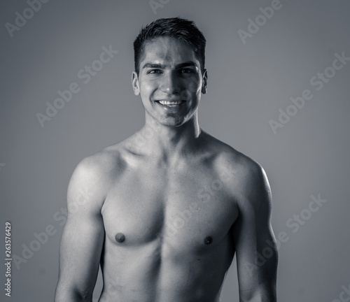 Portrait of strong handsome Athletic man feeling good and happy isolated on neutral background