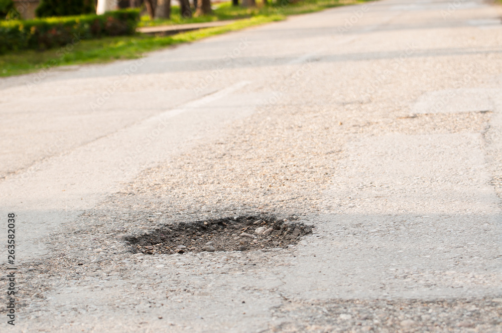 Holes on the road. dangerous pothole in the asphalt highway Holes on the road. dangerous pothole in the asphalt highway