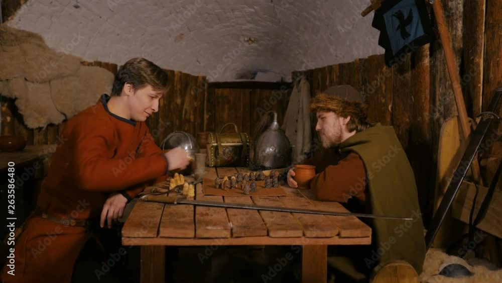 4 shots. Two men in russian ethnic suit playing medieval popular strategy board game - tafl. Folk, competition and traditional concept 4 shots. Two men in russian ethnic suit playing medieval popular strategy board game - tafl. Folk, competition and traditional concept
