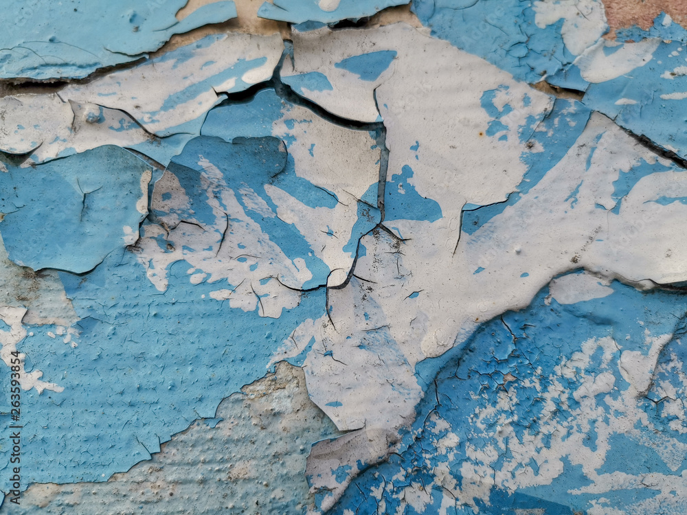 Blue background with cracked oil paint on plaster.