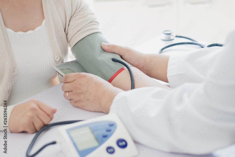The doctor measures blood pressure to the patient The doctor measures blood pressure to the patient