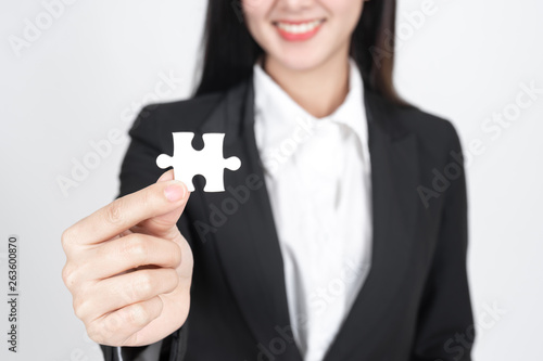business woman holding and showing a jigsaw puzzle - business concept