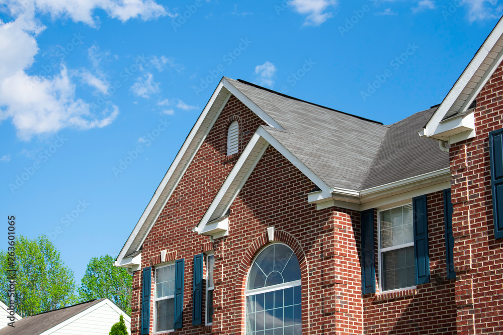 Residential Home with roofing gutters windows and blue sky