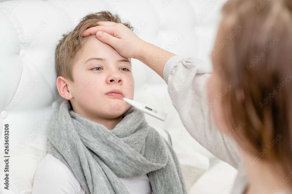 Mom touches the forehead of the child, checking the temperature