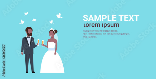 just married african american couple standing together bride and groom holding champagne glasses wedding day concept copy space full length horizontal flat