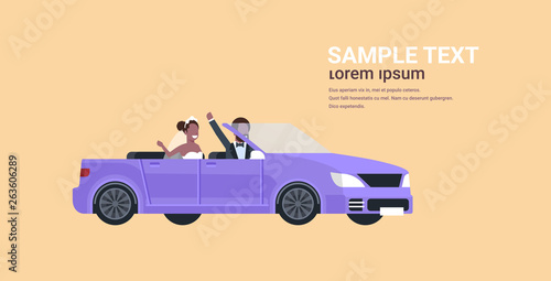 just married bridegroom and bride on road trip driving convertible car romantic african american couple in love wedding day concept yellow background copy space full length horizontal flat