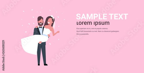 just married bridegroom holding bride on hands romantic couple man woman in love wedding day concept pink background copy space full length horizontal flat