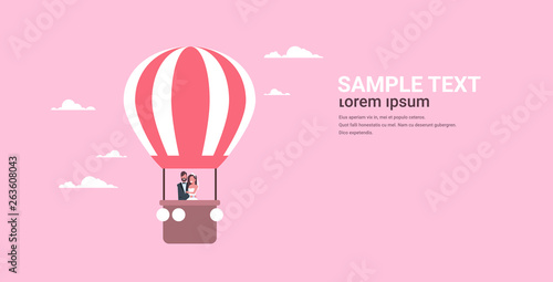 just married bridegroom and bride flying in air balloon romantic couple man woman in love wedding day concept pink background copy space full length horizontal flat