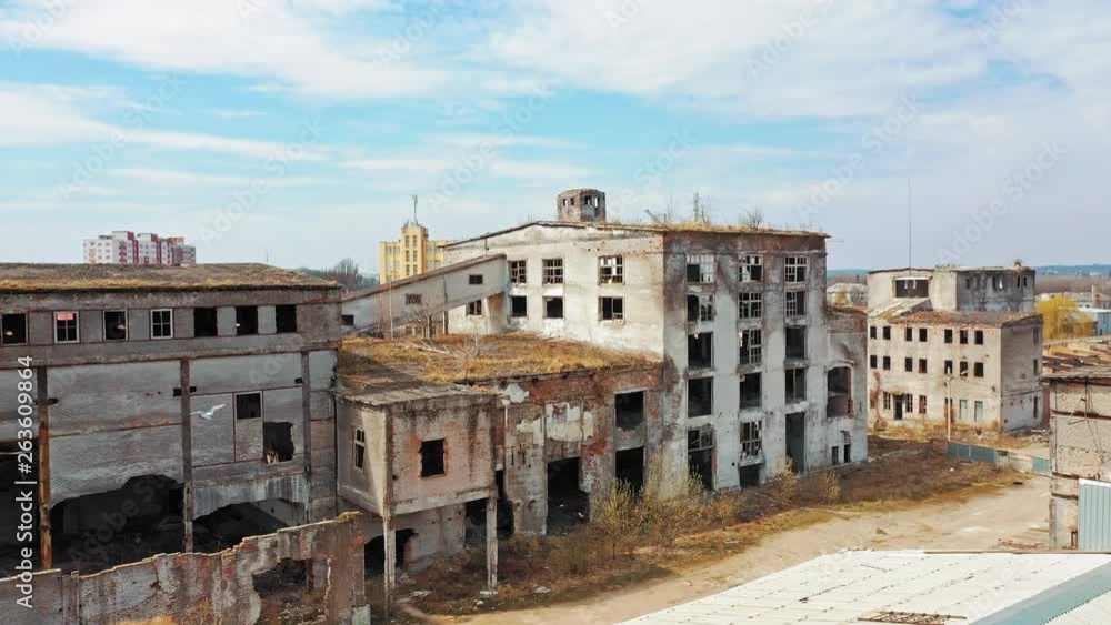 Aerial view of abandoned buildings, ruined after military actions. Destroyed industrial architecture with broken windows and big holes. Camera moves forward. Aerial view of abandoned buildings, ruined after military actions. Destroyed industrial architecture with broken windows and big holes. Camera moves forward.