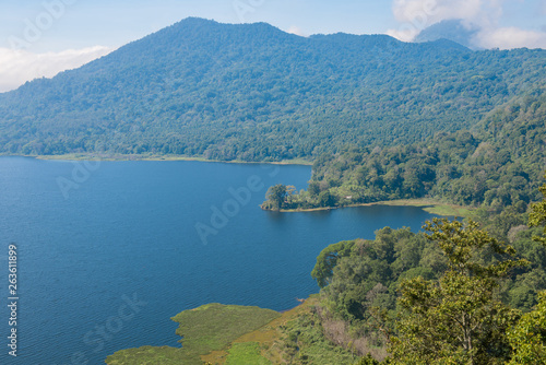 View of Lake Buyan on Bali island, Indonesia. It's Bali’s second biggest lake. Volcanoes have created and shaped this island and producing rich soils enabling a lush forest to grow.