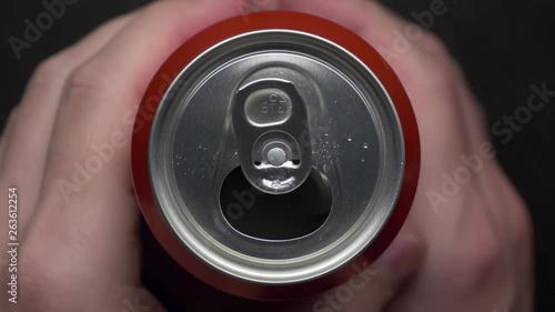 top view of white man open red can of soda or beer. unhealthy eating. hand opening. Slow motion video medium extreme close up high angle telephoto lens audio sound of the opening drink