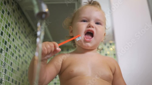 Baby in the sink. Baby is sitting in the kitchen sink and touched the water from the tap. baby washes his hands