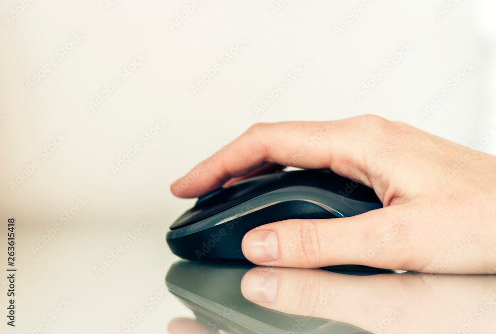 Close-up of hand woman using a computer mouse on glass table, business concept. Close-up of hand woman using a computer mouse on glass table, business concept.