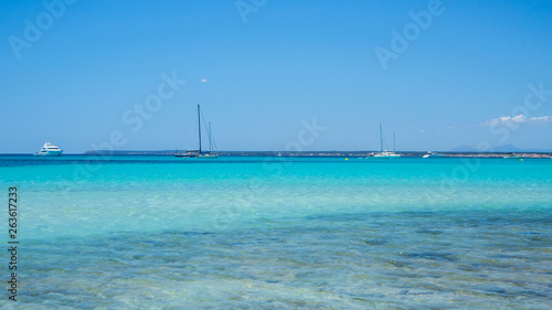 Colonia Sant Jordi  Ses Salines  Spain. Amazing view of the boats in turquoise sea close to the charming beach of Es Trencs. It has earned the reputation of Caribbean beach of Mallorca