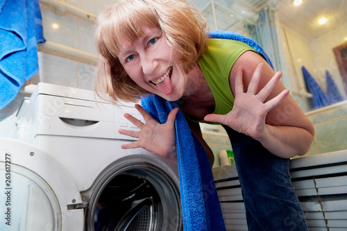 Housewife near washing machine doing selfie in the bath room
