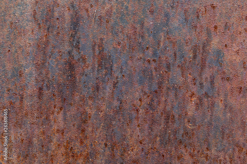 The old rusty surface of metal damaged by bad weather. Spots and smudges of paint. Ready photo background. Macro.