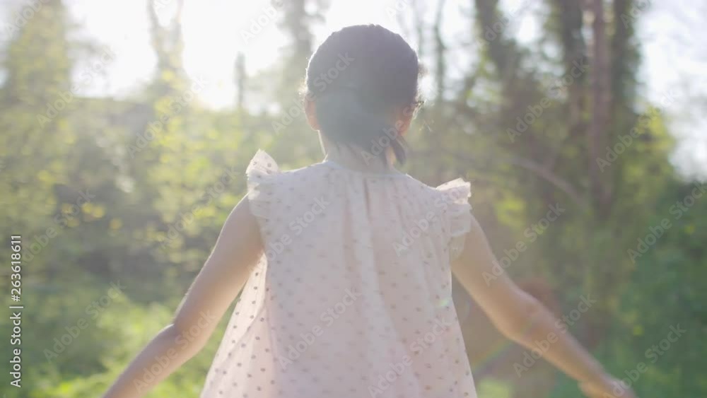 Young girl twirling in the sunlight, in slow motion Young girl twirling in the sunlight, in slow motion