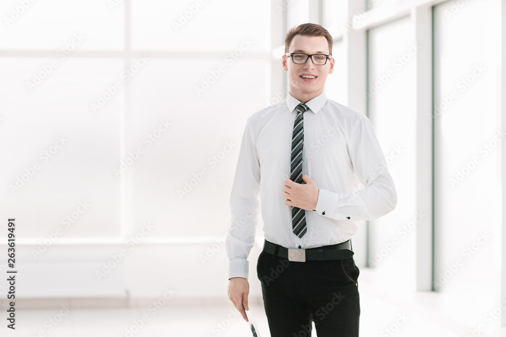 portrait of a young company employee standing in the office. portrait of a young company employee standing in the office.