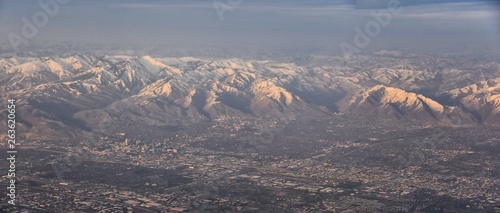 Aerial view from airplane of the Wasatch Front Rocky Mountain Range with snow capped peaks in winter including urban cities of Provo, Farmington Bountiful, Orem and Salt Lake City. Utah. United States