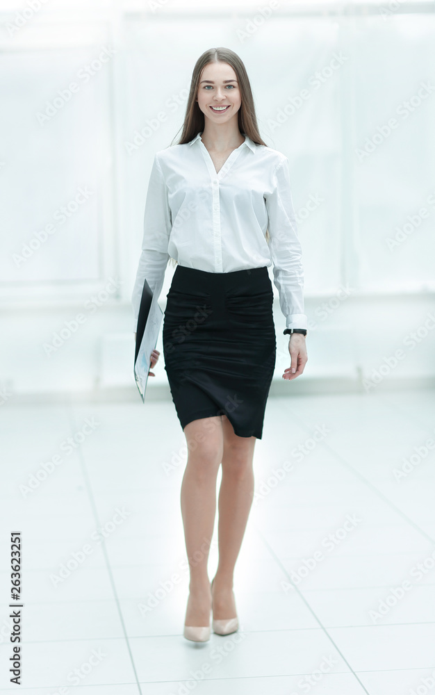 Beautiful confident businesswoman walking through a corridor Beautiful confident businesswoman walking through a corridor