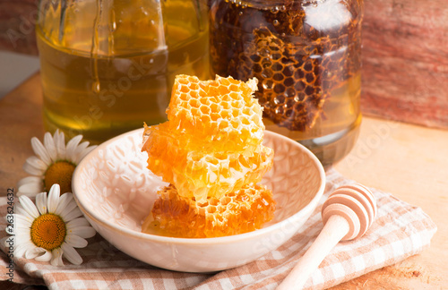 Fresh honeycombs in bowl on wooden background. closeup
